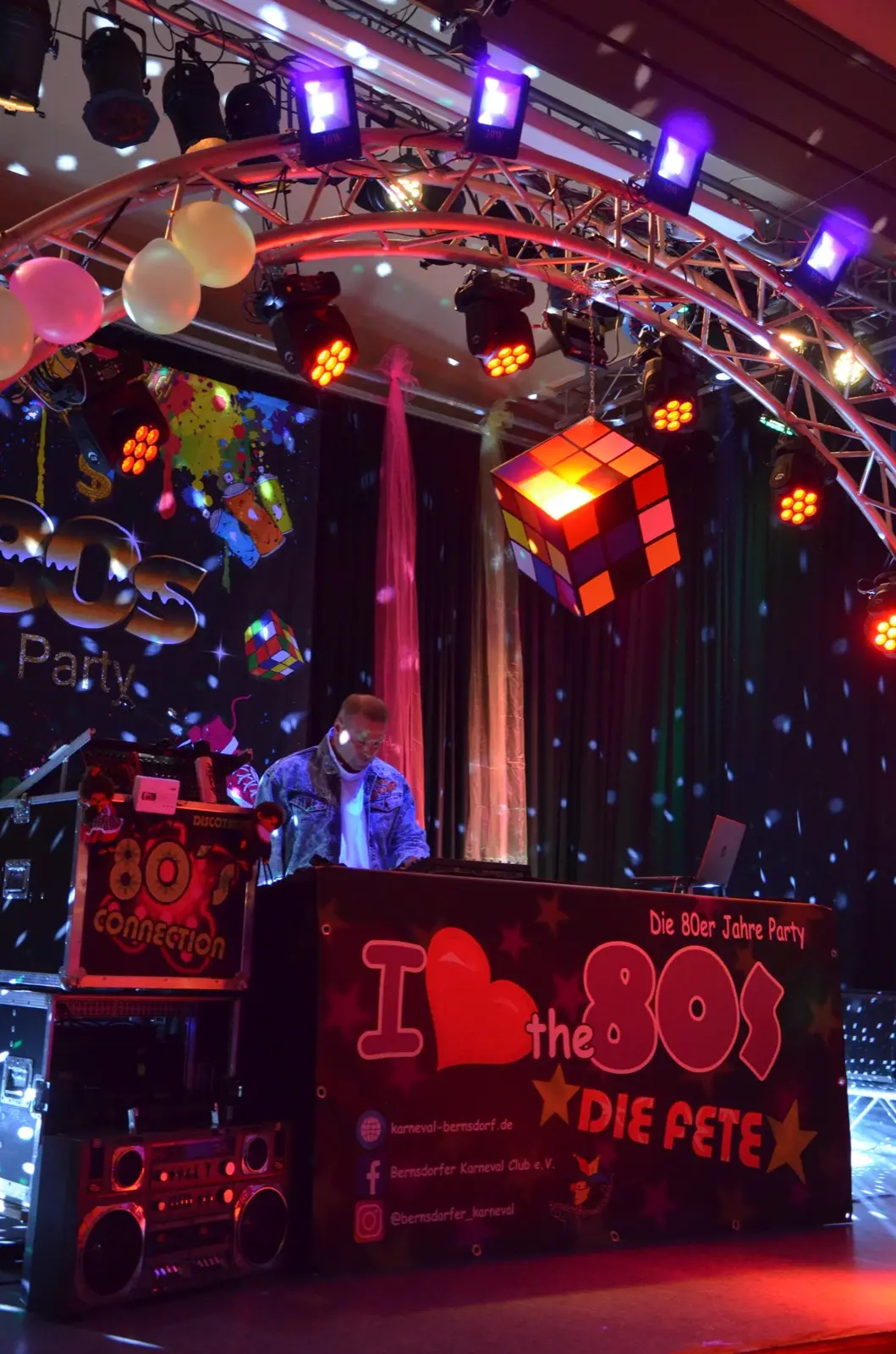 DJ-Pult mit leuchtender 80er-Dekoration